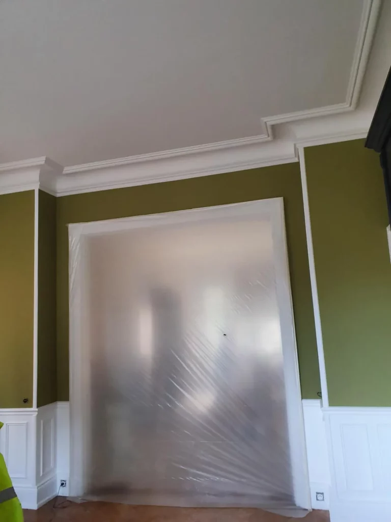 Mur vert olive et moulures blanches, finition haut de gamme