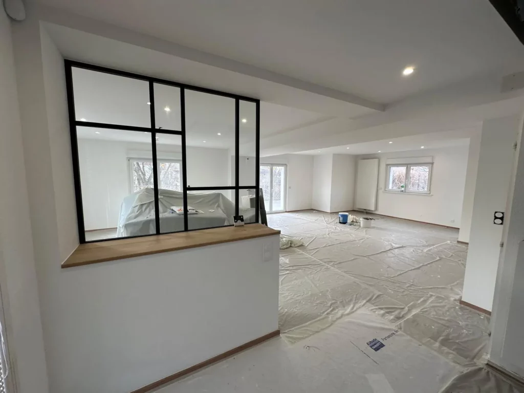 Espace ouvert avec verrière atelier et murs blancs
